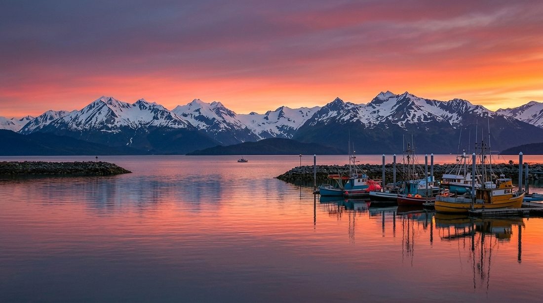 Sunset over an Alaskan harbor with snow-capped mountains