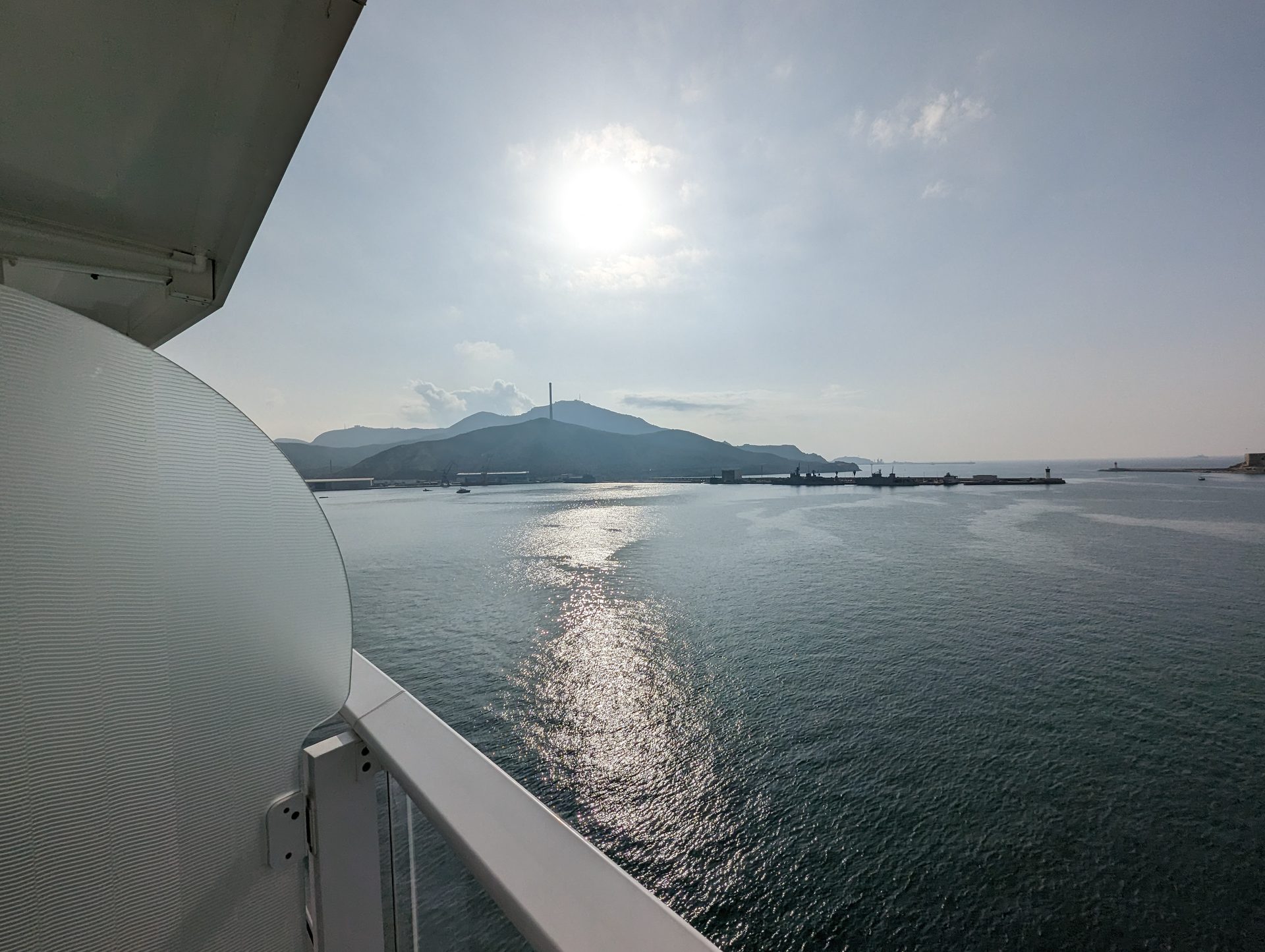View from a ship balcony — open sea and mountains